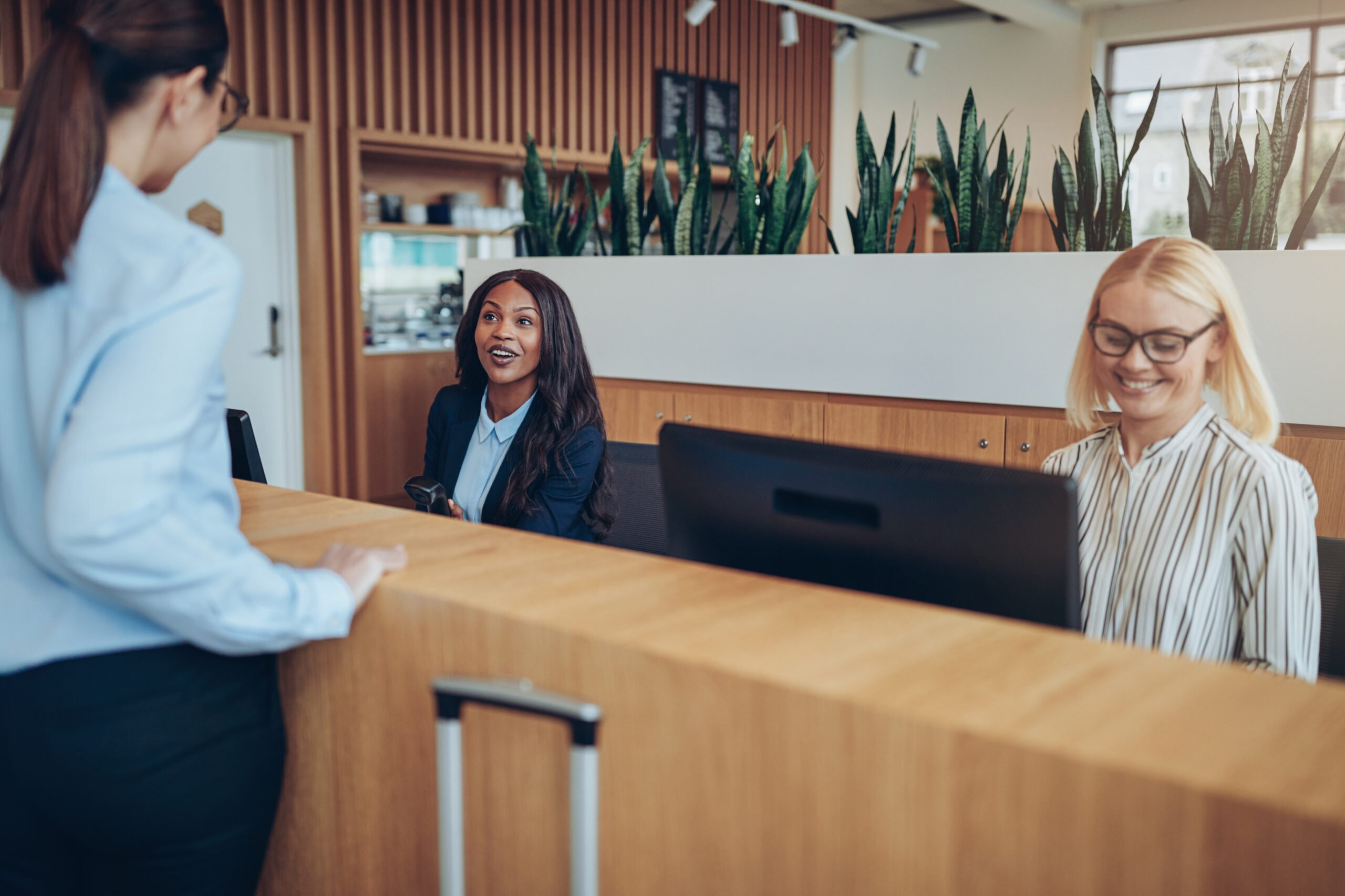 Smiling African American hotel concierge helping a guest check in